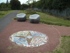 Ground mosaic and stone chairs at path junction, waypoint 2