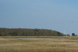Looking across the marshes, towards Yarmouth. On the skyline, just to the right of centre, is the bridge which crosses the River Yar. On the extreme right of picture, a Wightlink ferry is still in harbour.