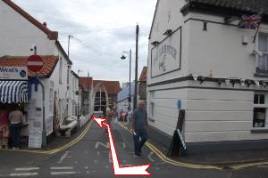 Photo 3.  Just when you get into sight of the promenade, turn right along Gun Street.  Notice the old cannon standing upright by the corner of the building. Then bear left passing the Oldfellows Hall and walk along the promenade.
